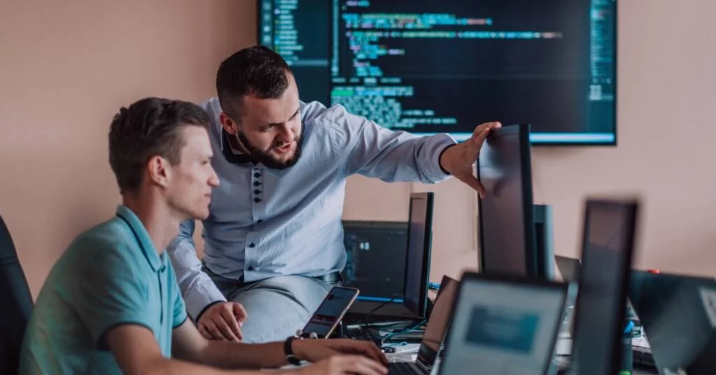 Two mens sits in a chair working in a computer